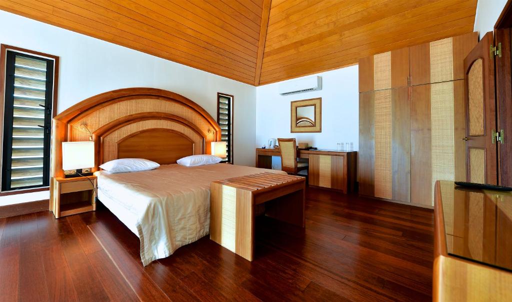 FayaouéHotel Paradis d'Ouvéa的一间卧室设有一张大床和木制天花板