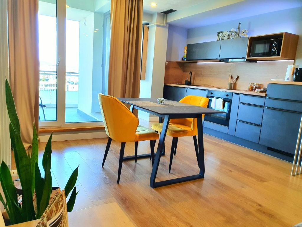 克卢日-纳波卡Eriss Studio Suite - OZone building apartment的厨房配有桌子和一些黄色的椅子