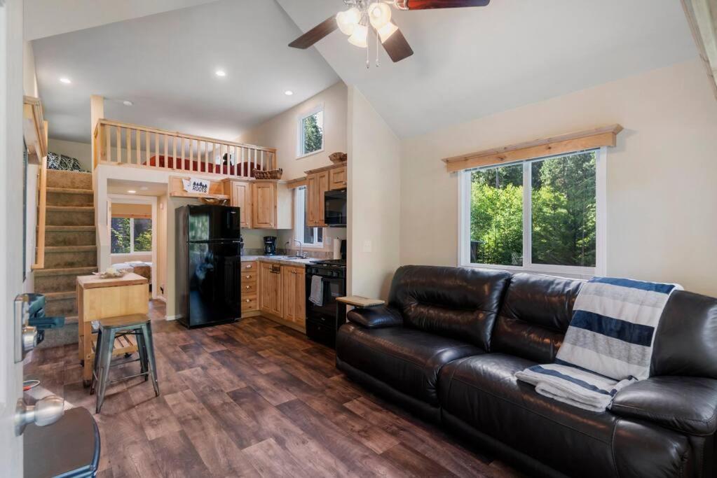 阿什福德New Tiny Home Steps Away From Mt. Rainier的一间带真皮沙发的客厅和一间厨房