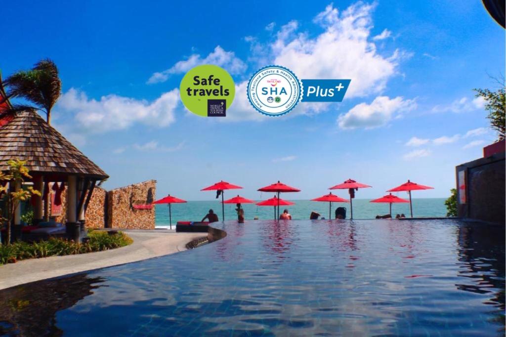 查汶Kirikayan Boutique Resort - SHA Extra Plus的度假村的游泳池,配有红伞