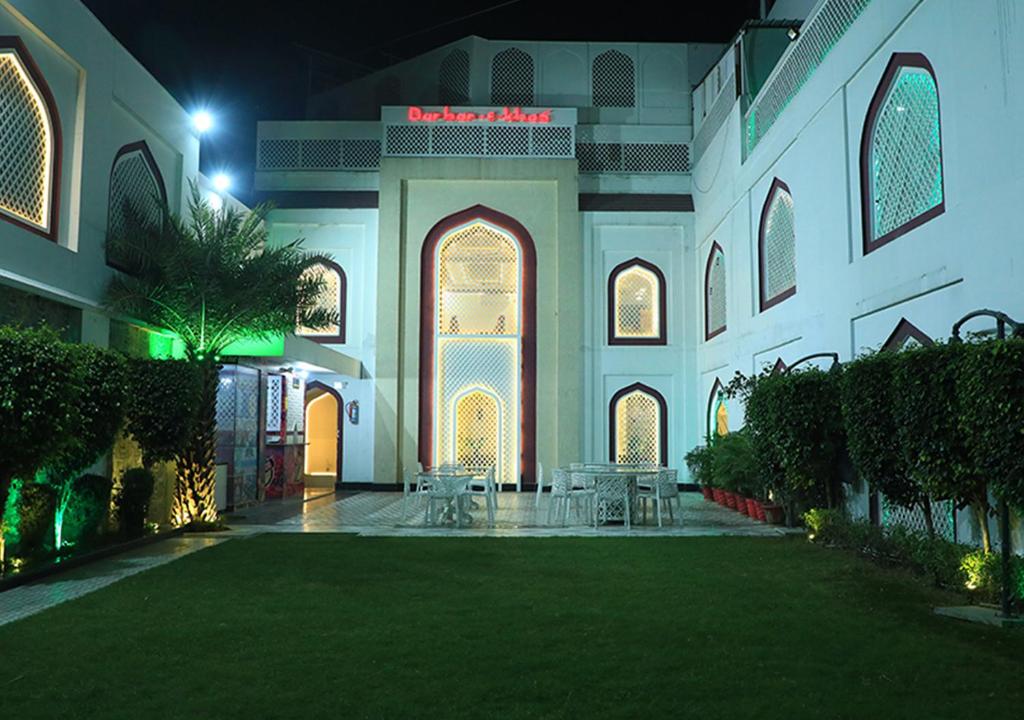 巴雷利Hotel Darbar-E-Khas A member of Crimson Hotels的清真寺的庭院,晚上有桌椅