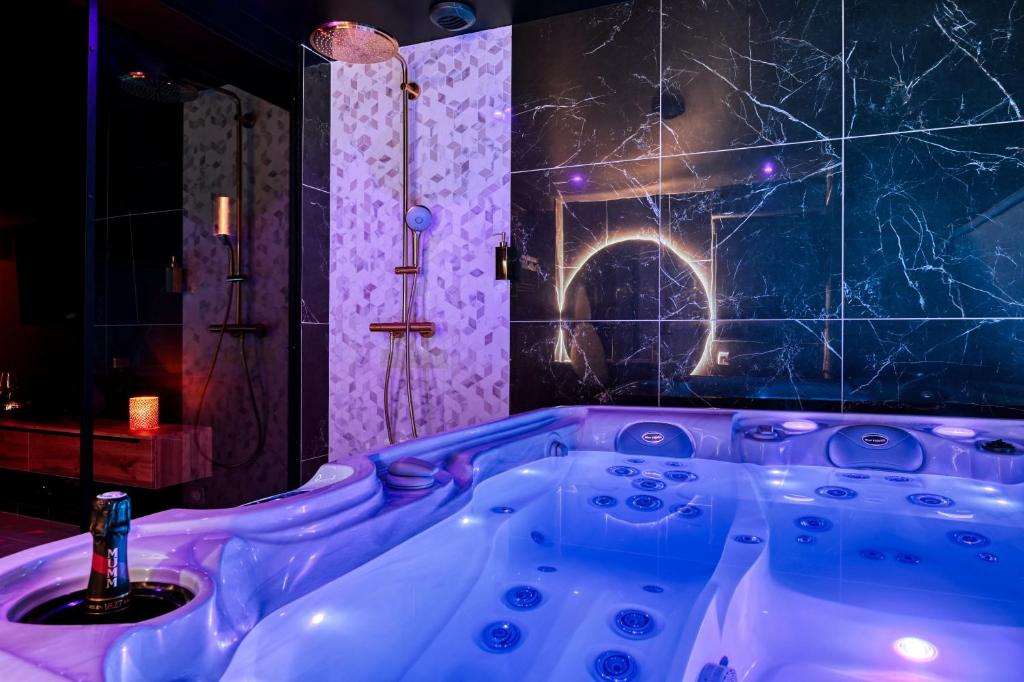 圣西尔-莱科勒Villa avec jacuzzi privatif的带淋浴的客房内的紫色浴缸