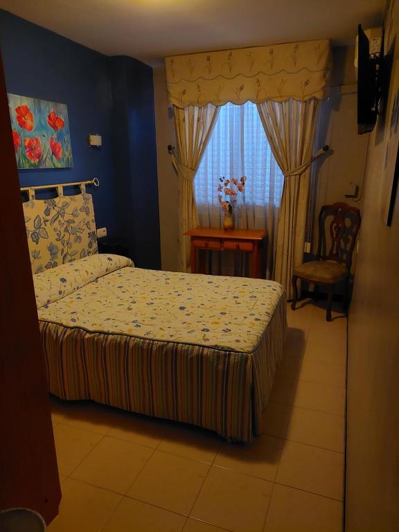 莫特里尔Pensión Colonia的一间卧室设有一张床和一个窗口