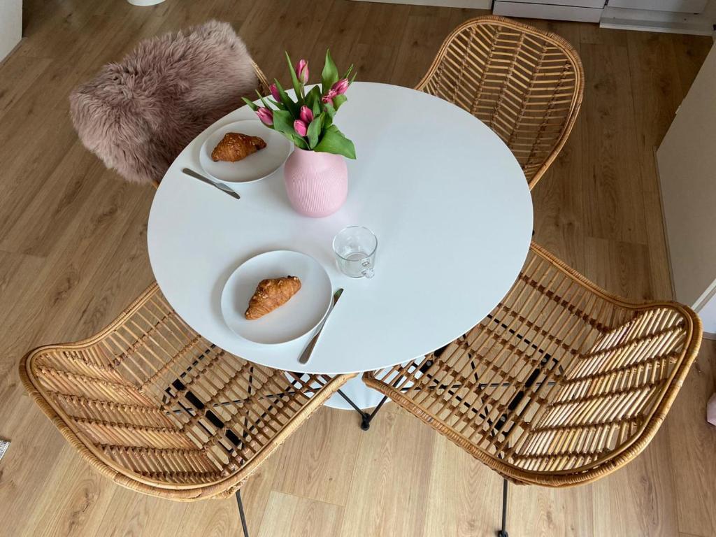滨海贝亨zilvermeeuw的一张带两把椅子的白色桌子和一盘食物