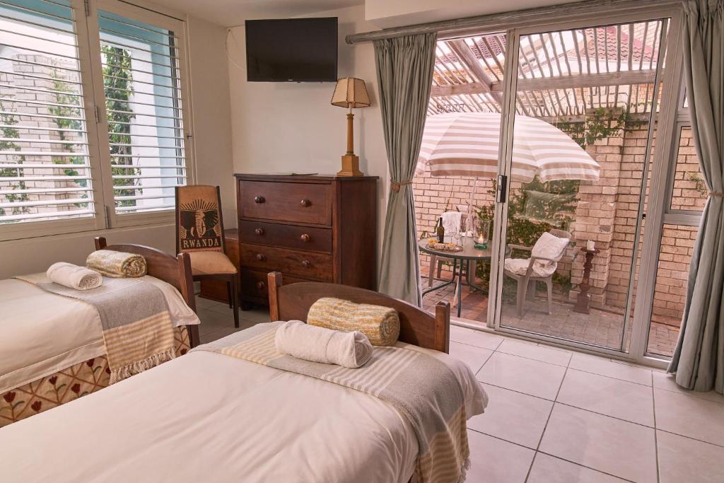 杰弗里湾Soul Searchers的一间卧室设有两张床,享有庭院的景色