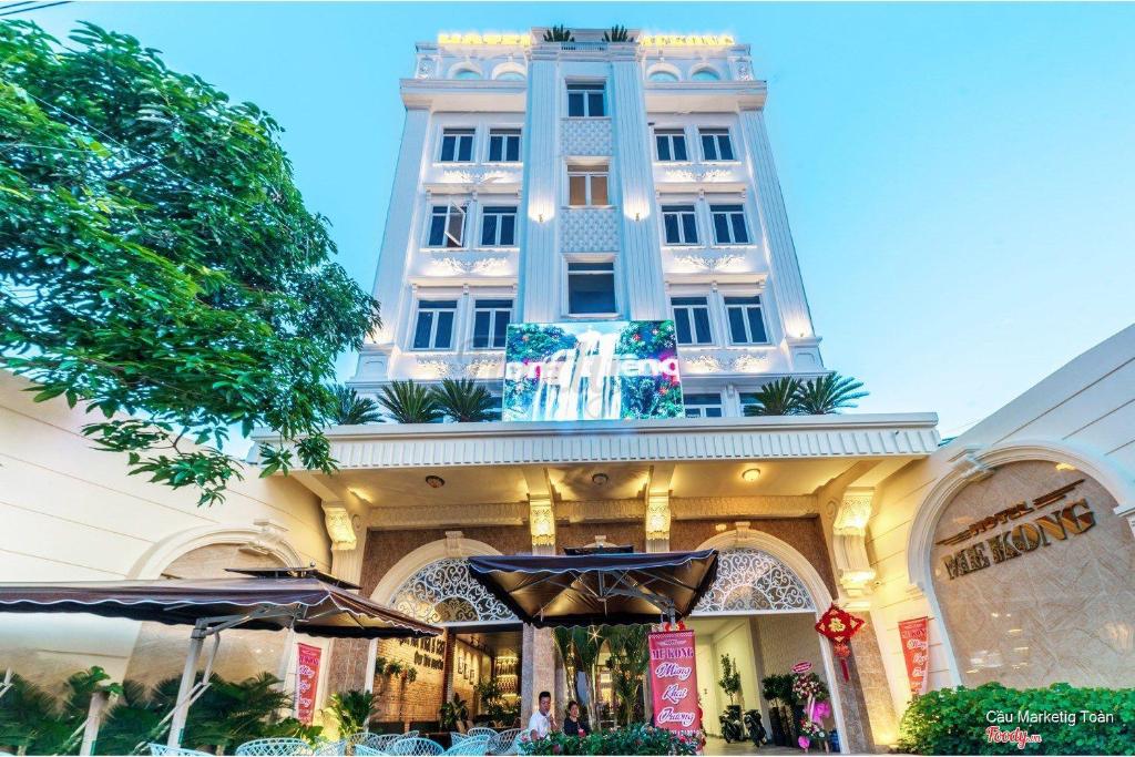 波来古市Mekong Gia Lai Hotel - Me Kong Pleiku的一座大建筑前面设有桌子和遮阳伞