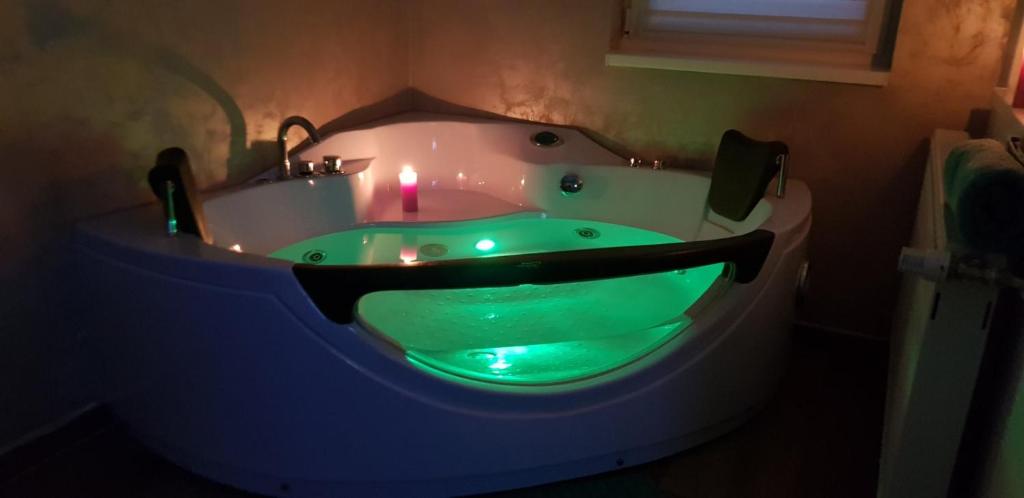 苏博蒂察Jacuzzi Room的浴室设有绿色浴缸,内配蜡烛
