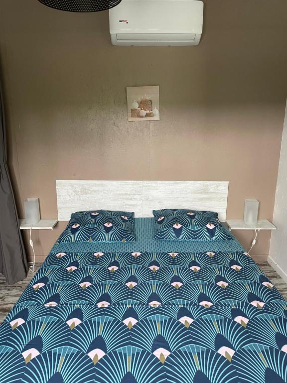 勒弗朗索瓦Villas Smoothie Papaya的卧室内的一张带蓝色和白色棉被的床