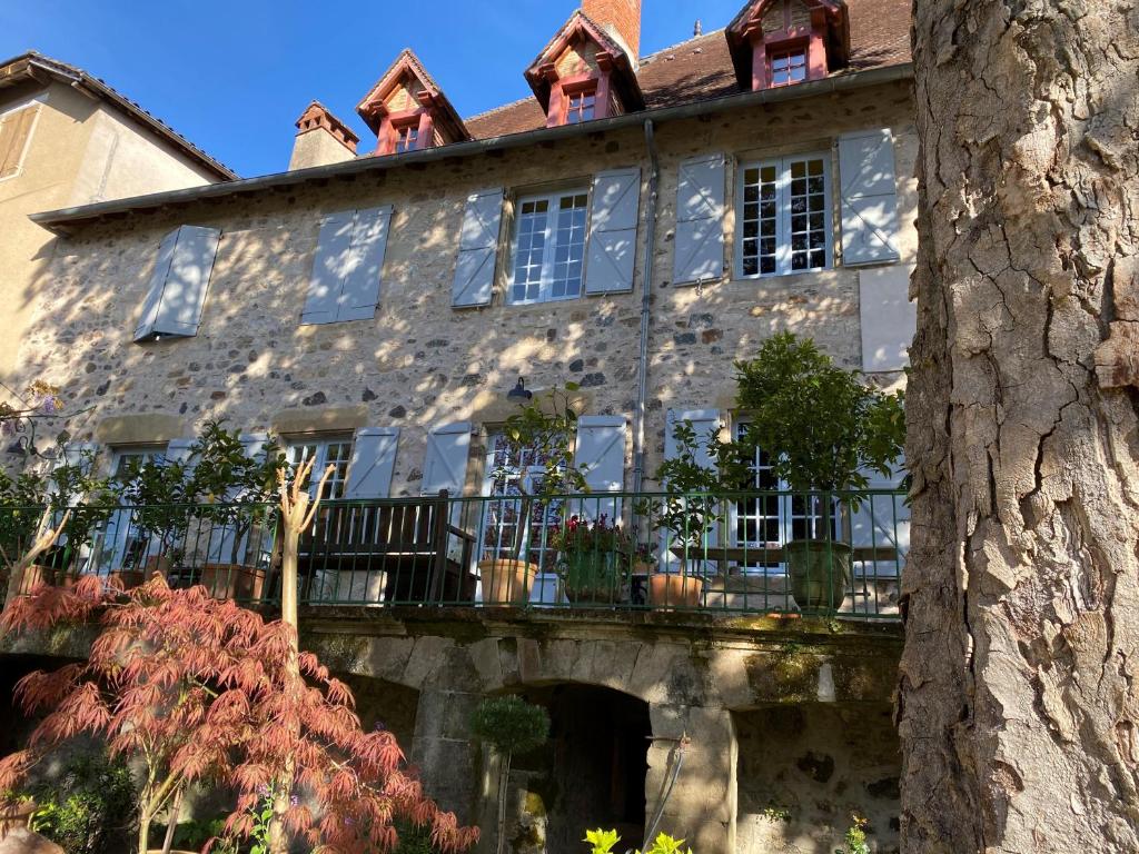 多尔多尼河畔博利厄Le Clos Rodolphe的一座古老的石头房子,设有阳台和一棵树