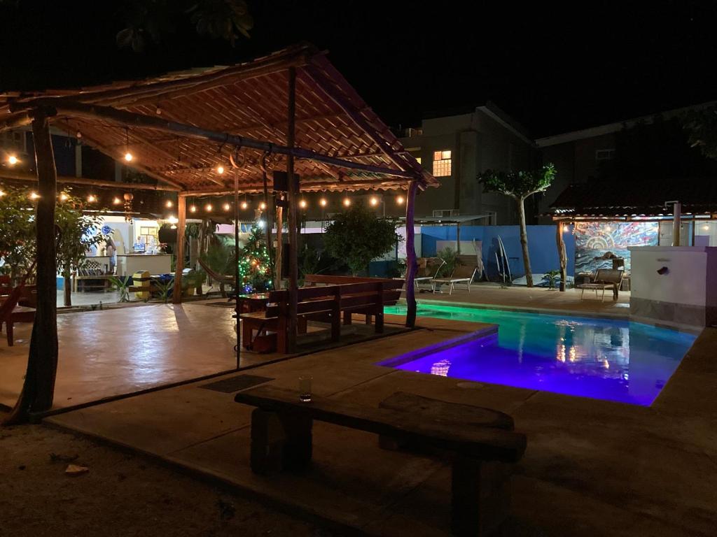 塔马林多TamaHostel & Glamping的夜间游泳池,配有帐篷和野餐桌