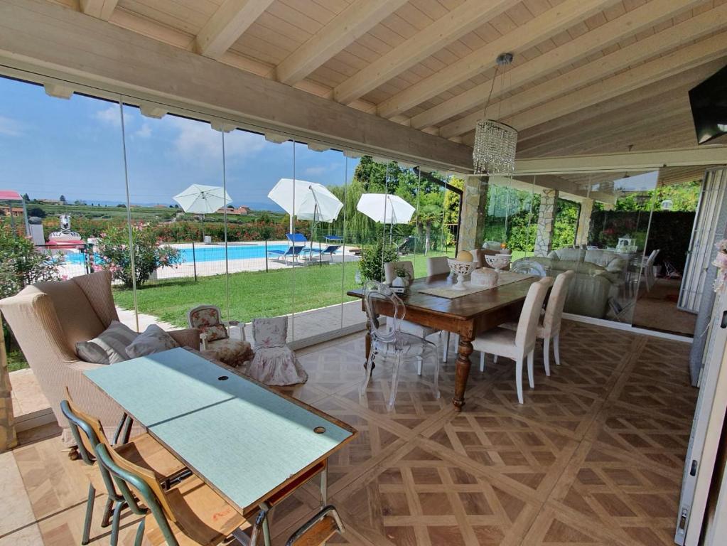 巴多利诺Villa Claudia的一间带桌椅的客厅和一个游泳池