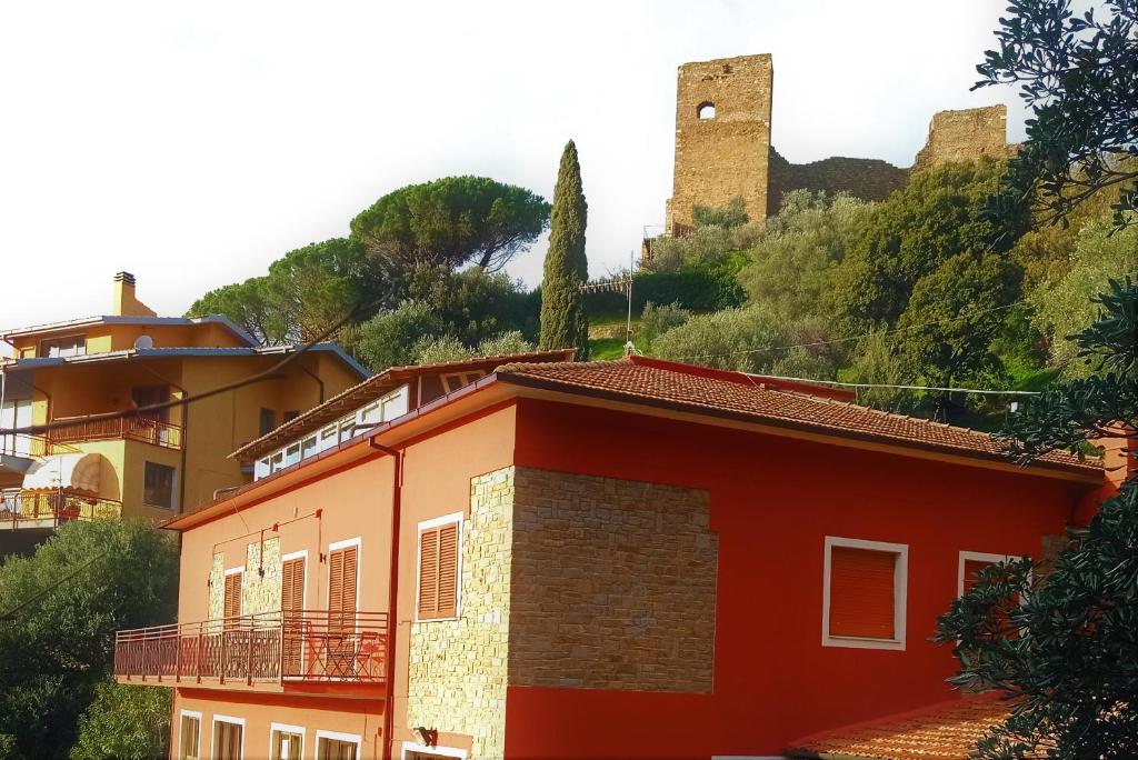 斯卡尔利诺ROMANTICA TOSCANA的一座红色的建筑,后面有一座城堡