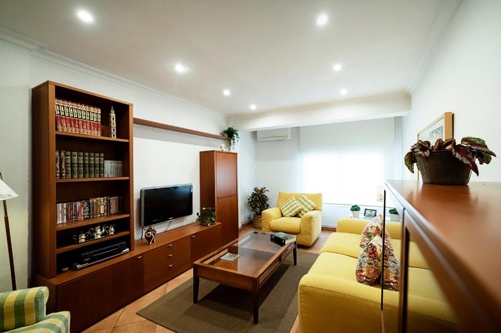 昆卡La Picaceña的客厅设有黄色沙发和电视
