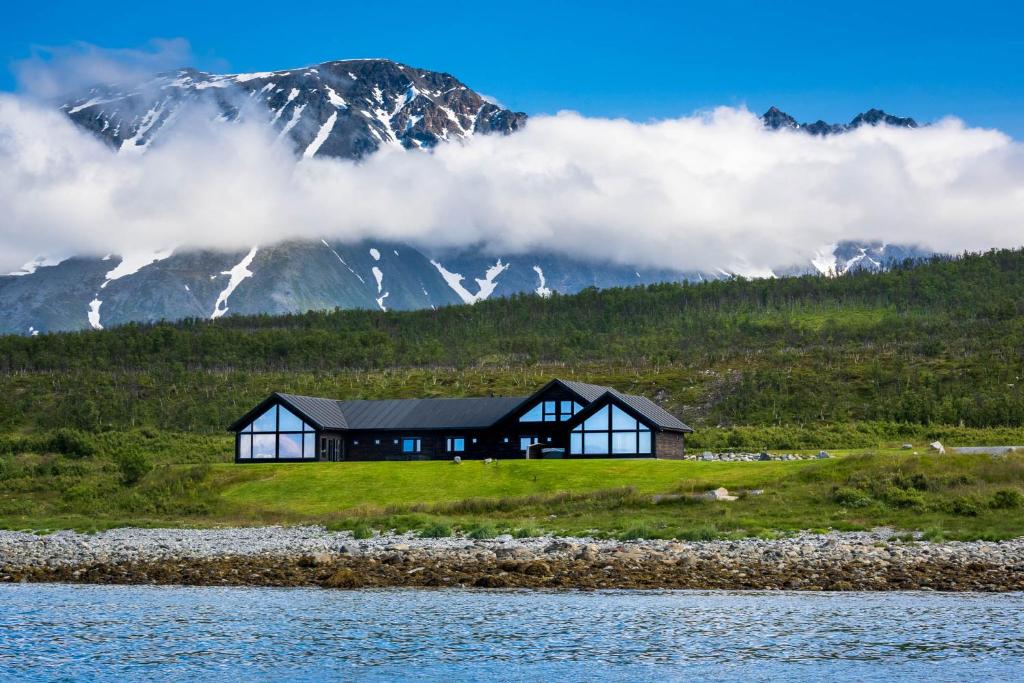 Nord-LenangenLyngen Experience Lodge的山丘上的房子,背景是山