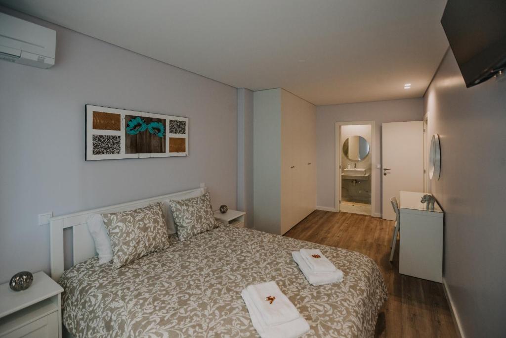 布拉加Alojamento Amélie - Apartamento的一间卧室配有一张床,上面有两条毛巾