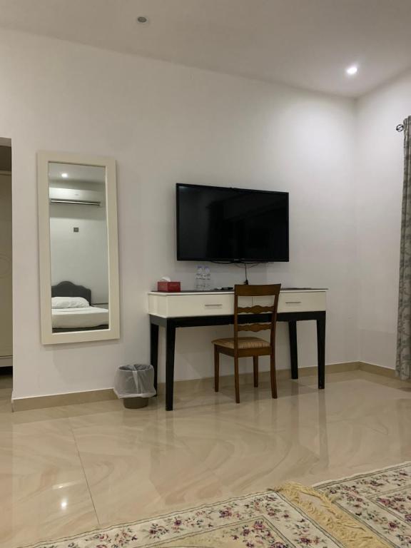 Al Wāşil东方之夜酒店的客房设有书桌、电视和椅子