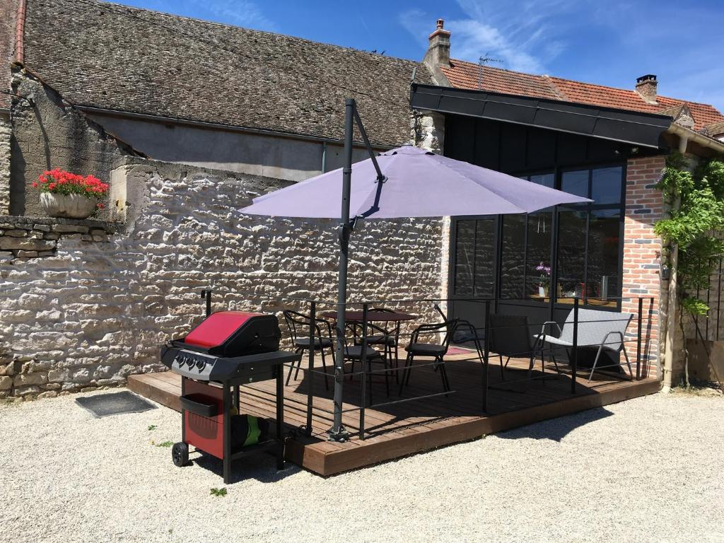 Corcelles-les-ArtsL'Atelier 1的露台上的烧烤架和遮阳伞
