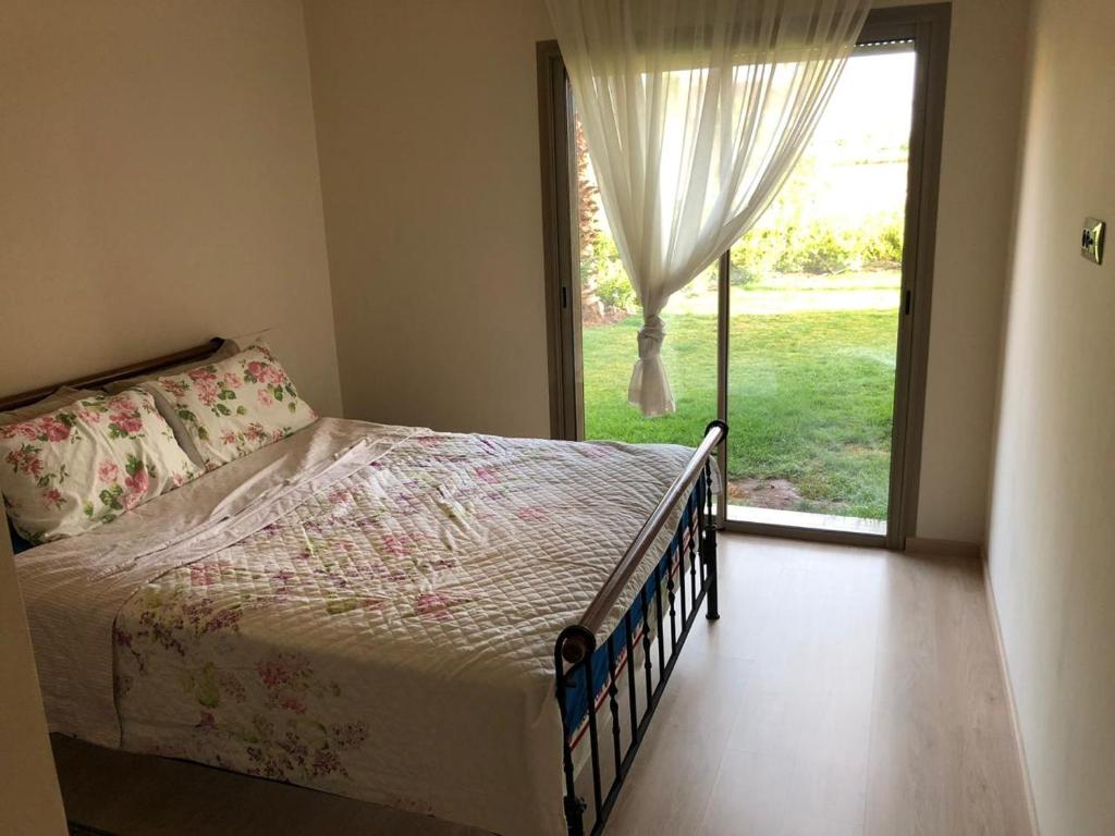 马拉喀什Au Rez de jardin, Bel appt au sein du golf Montgomery的一间卧室设有一张床和一个大窗户