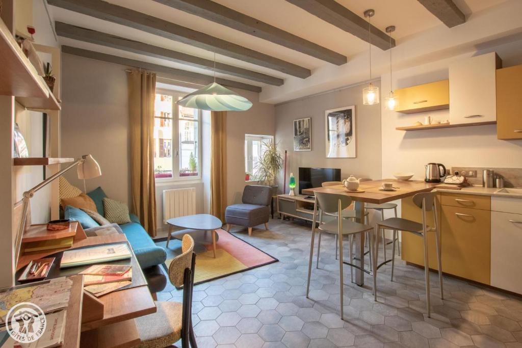 安锡Gite urbain AU 2BIS - Annecy的厨房以及带桌椅的起居室。