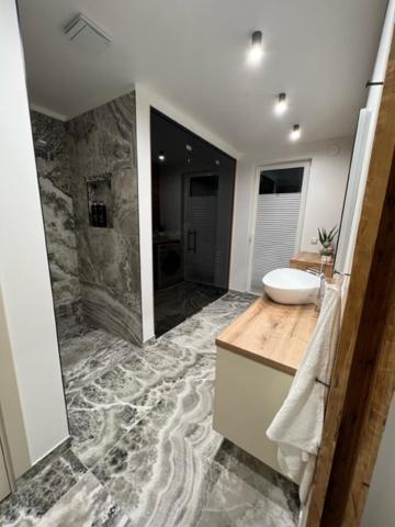 沃鲁Ranna Apartment的大型浴室设有水槽和淋浴。