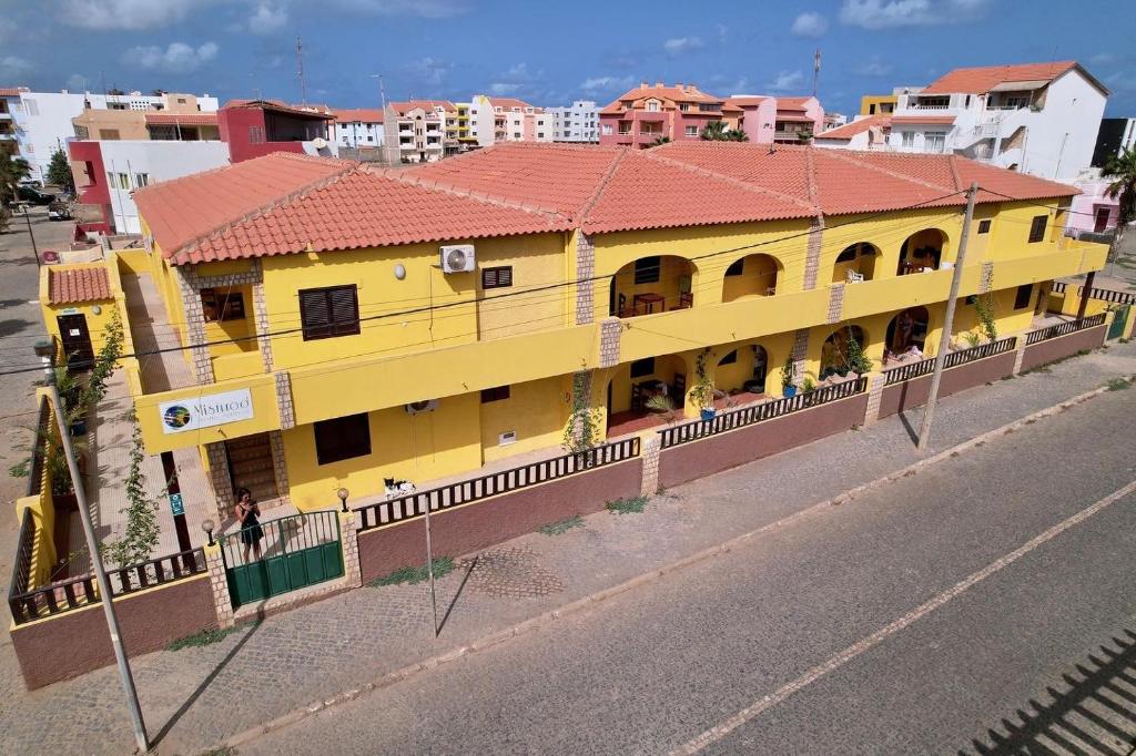 圣玛丽亚Misturod - Holiday Apartments的街道边有红色屋顶的黄色建筑