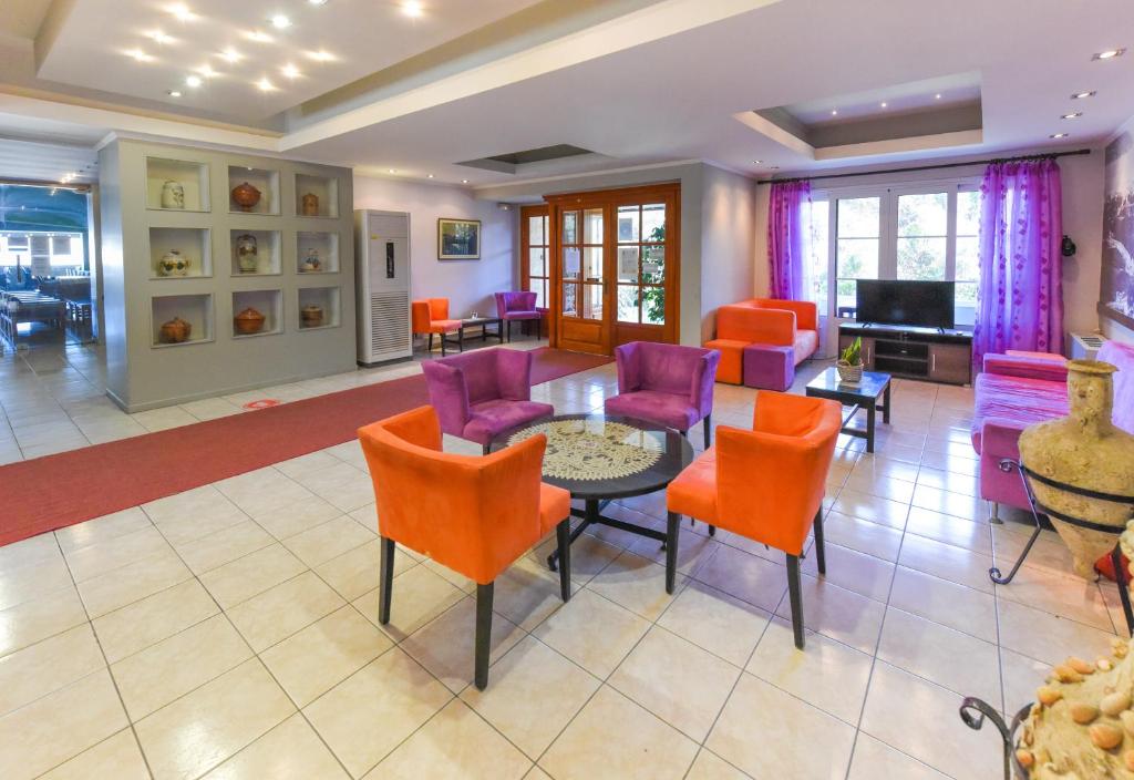 萨摩斯天堂酒店的客厅配有五颜六色的椅子和桌子