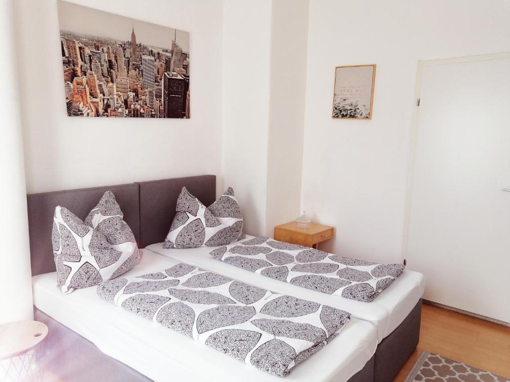 格拉茨Betterhome Apartments am Stadion的卧室配有带灰色和白色枕头的床