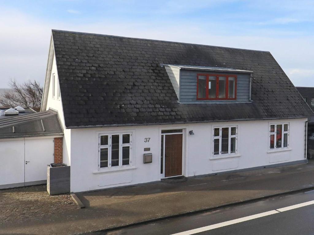 埃斯比约Holiday home Esbjerg V XX的街上有黑屋顶的白色房子
