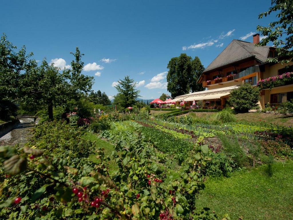 Gödersdorf左纳酒店的鲜花盛开的花园以及背景建筑