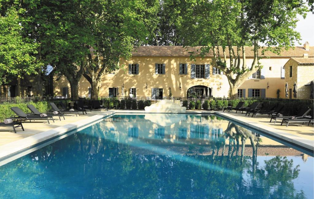 莱博德普罗旺斯多曼尼德曼维尔酒店的一座大楼前的游泳池,带喷泉