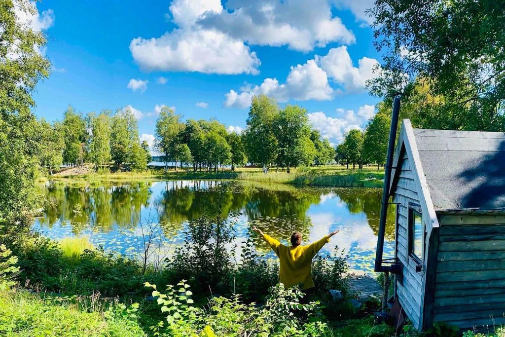 StjärnsundRomantic Cabin right on the lake with fire place的站在湖前,手臂伸出