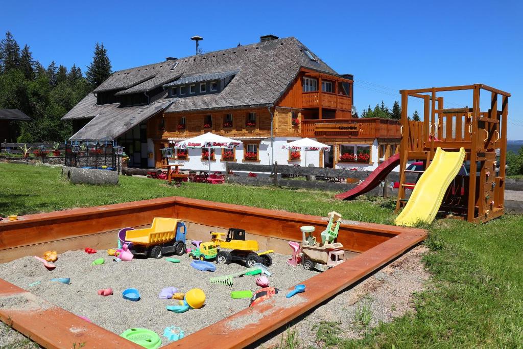 黑林山区邦多夫Ferienwohnung Waldrauschen in der Höhenpension Glashütte的房屋前的沙箱,里面装有玩具