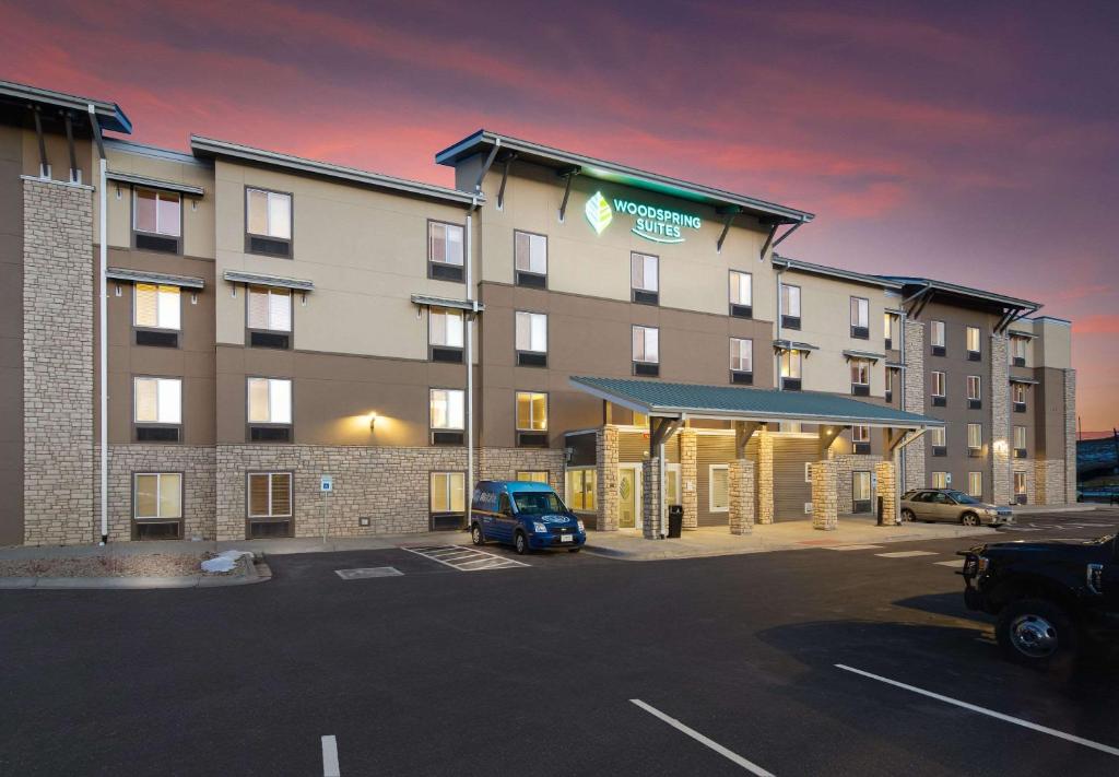 布鲁姆菲尔德WoodSpring Suites Broomfield-Westminster的停车场内有停车位的酒店