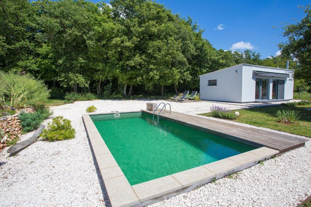 罗波里卡Cottage House Loborika with Pool的后院的游泳池,有一个小房子