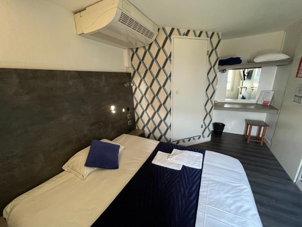 圣萨蒂南勒芒法斯特酒店的一间卧室配有一张带蓝色枕头的床