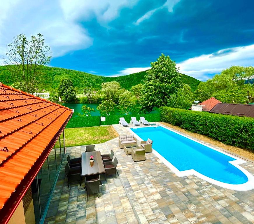 比哈奇Crystal Račić的一个带游泳池、椅子和房子的庭院