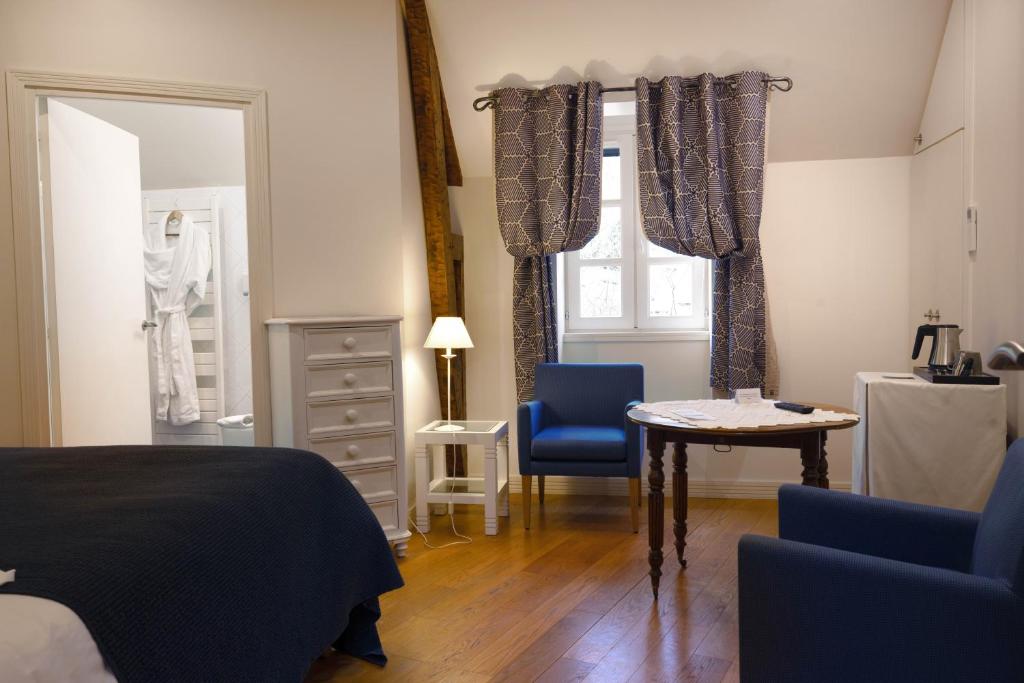 BelcastelLe Vieux Pont的卧室配有一张床和一张桌子及椅子