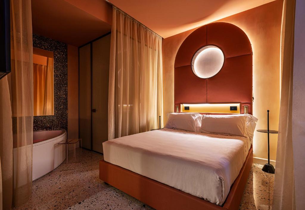 米兰恩特普莱斯设计精品酒店的一间卧室配有一张床和浴缸