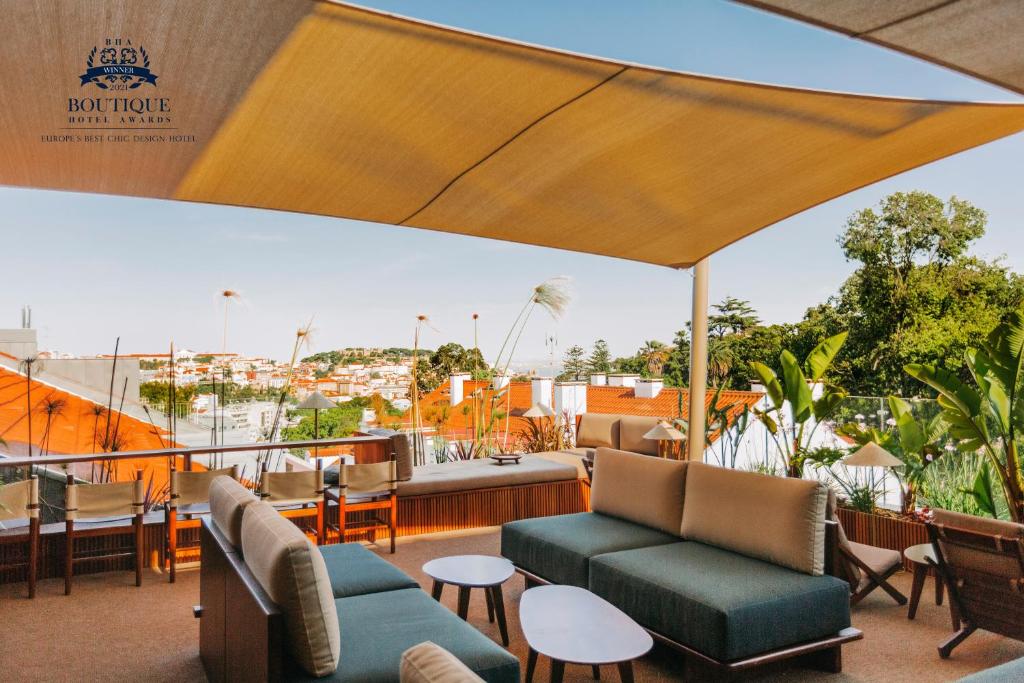 里斯本The Vintage Hotel & Spa Lisbon的屋顶上带沙发和椅子的庭院