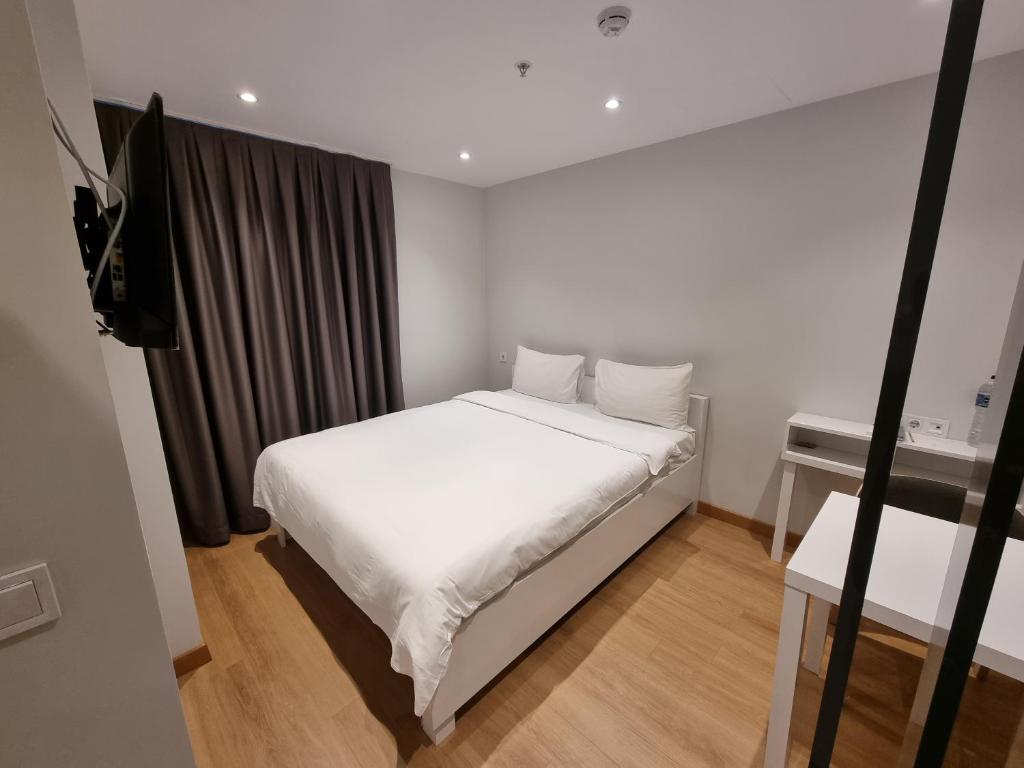 伊斯坦布尔10m2 Hotel的卧室配有白色的床和电视。