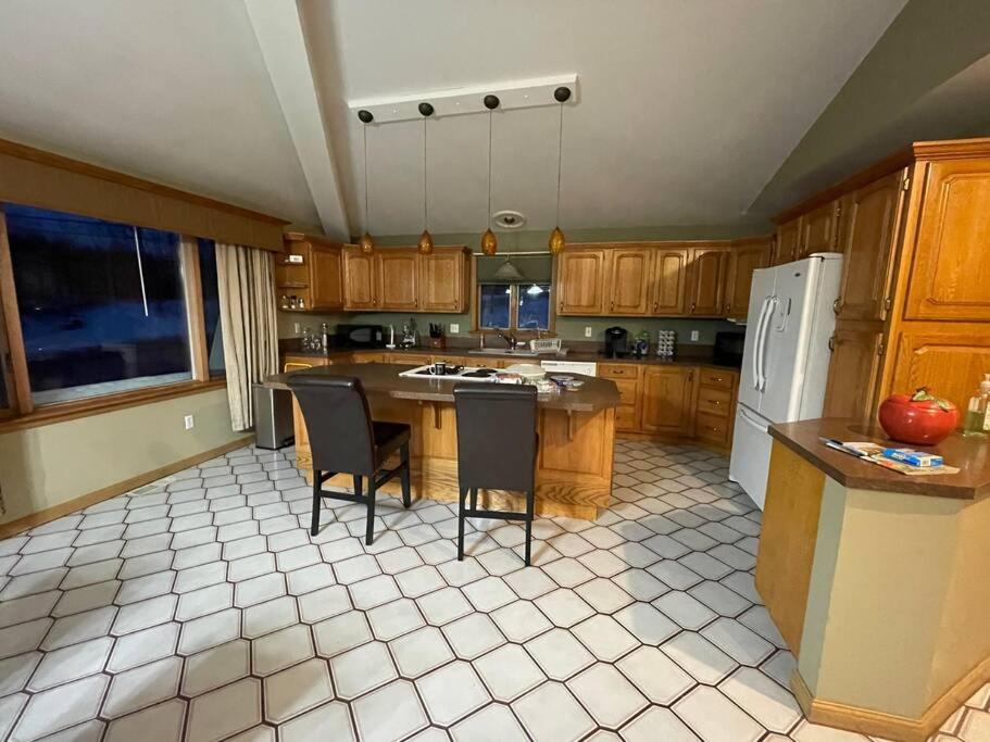 CaribouLuxury 3-Bedroom home的厨房配有桌椅和冰箱。