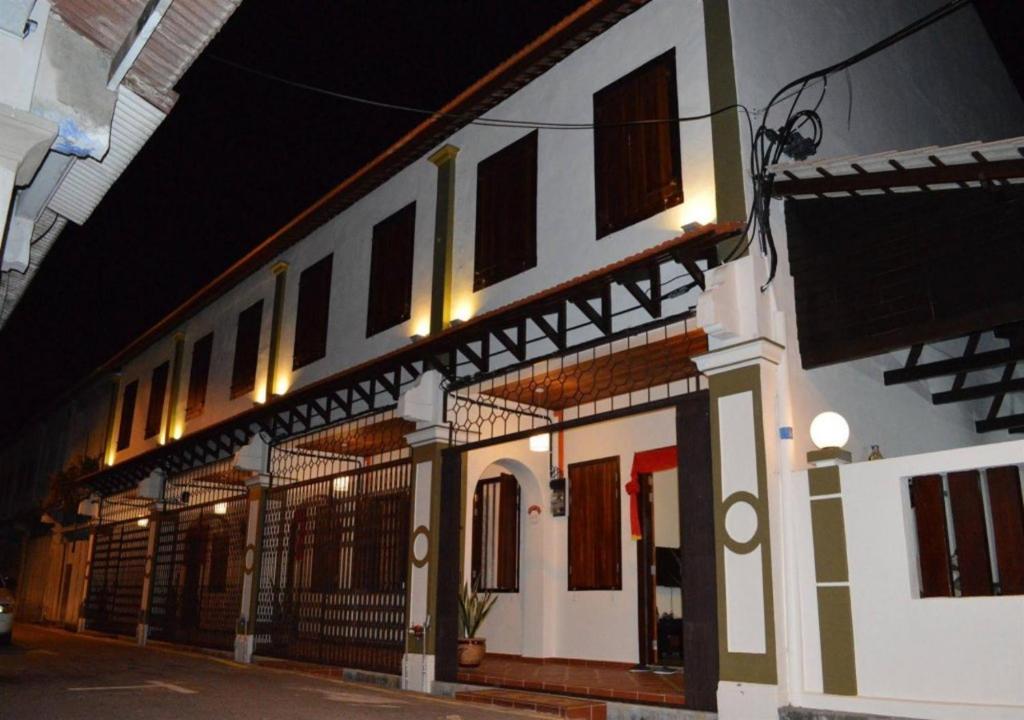 马六甲Jawa Townstay的白色的建筑,晚上在街上有窗户