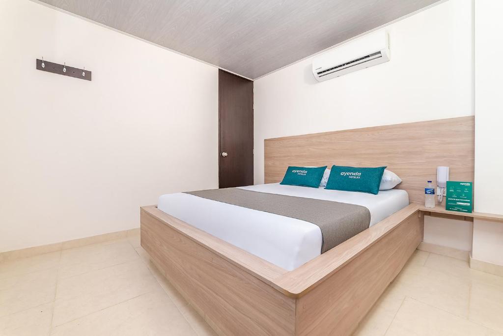 库库塔Ayenda Hospedaje WIV的卧室配有带蓝色枕头的大型白色床