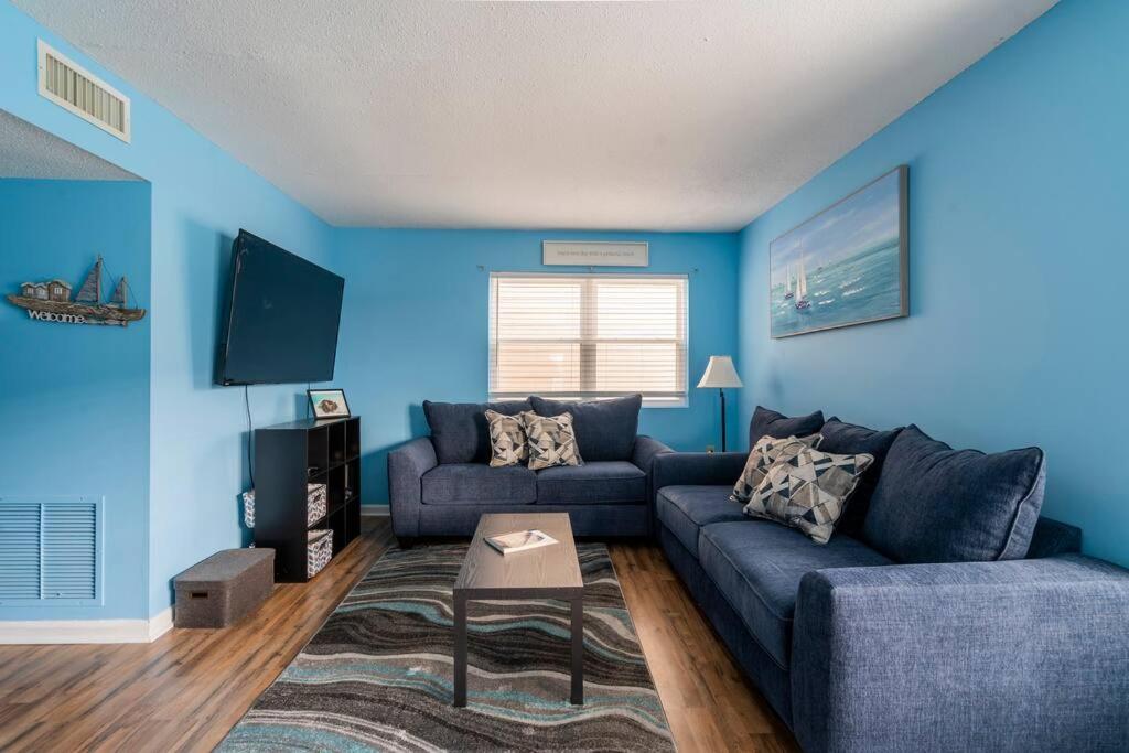 默特尔比奇Beautiful Blue Ocean Condo的客厅拥有蓝色的墙壁和蓝色的沙发