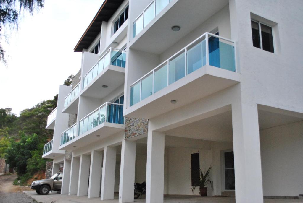 海地角Vue Apartment Hotel的带阳台的白色建筑,前面设有停车场