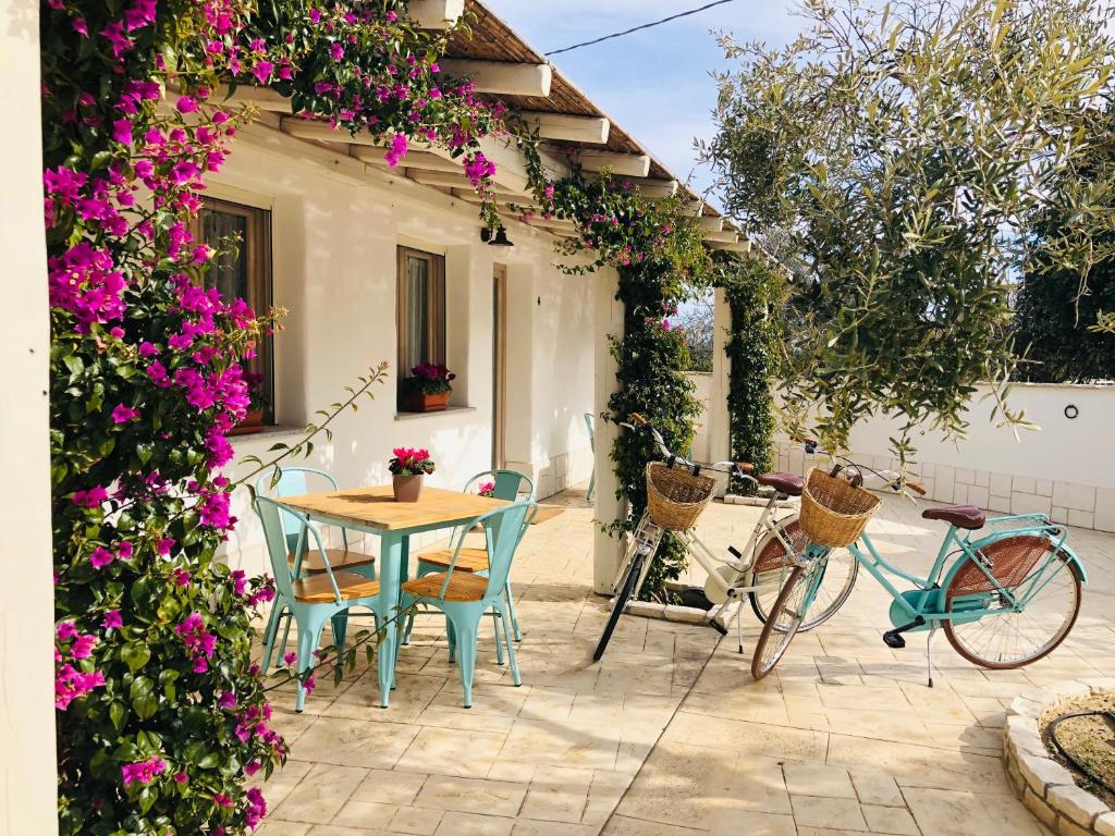 圣乔瓦尼-苏埃尔朱Domus Deiana Case Vacanza的庭院配有桌椅和鲜花