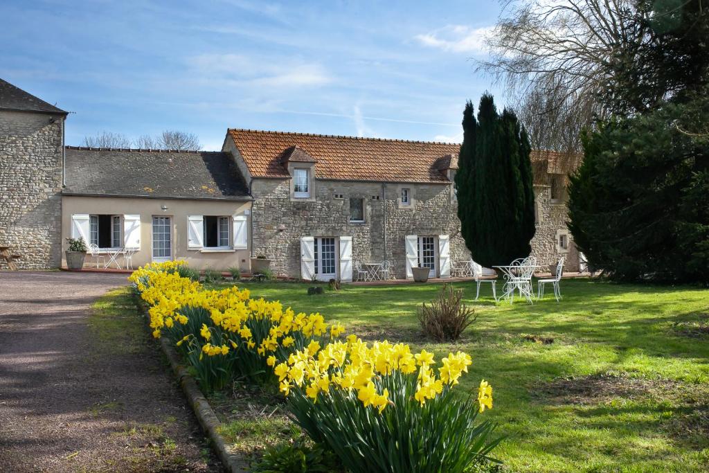 MaisonsFerme des Goupillières的前面有黄色水仙的房子