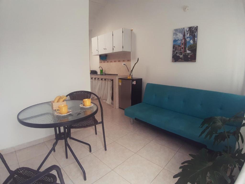 拉特瓦伊达Apartamento amoblado en La Tebaida, Quindio的客厅配有蓝色的沙发和桌子