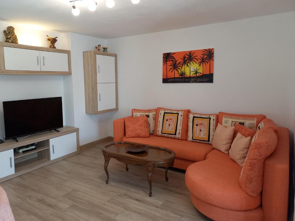 蒂亚斯Apartamento Via Mare的客厅配有橙色沙发和电视