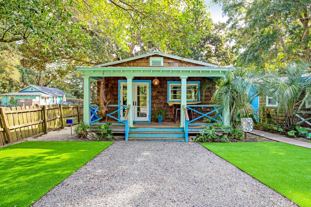 富丽海滩This Place Cottage B的一座带栅栏和草地的蓝色小房子